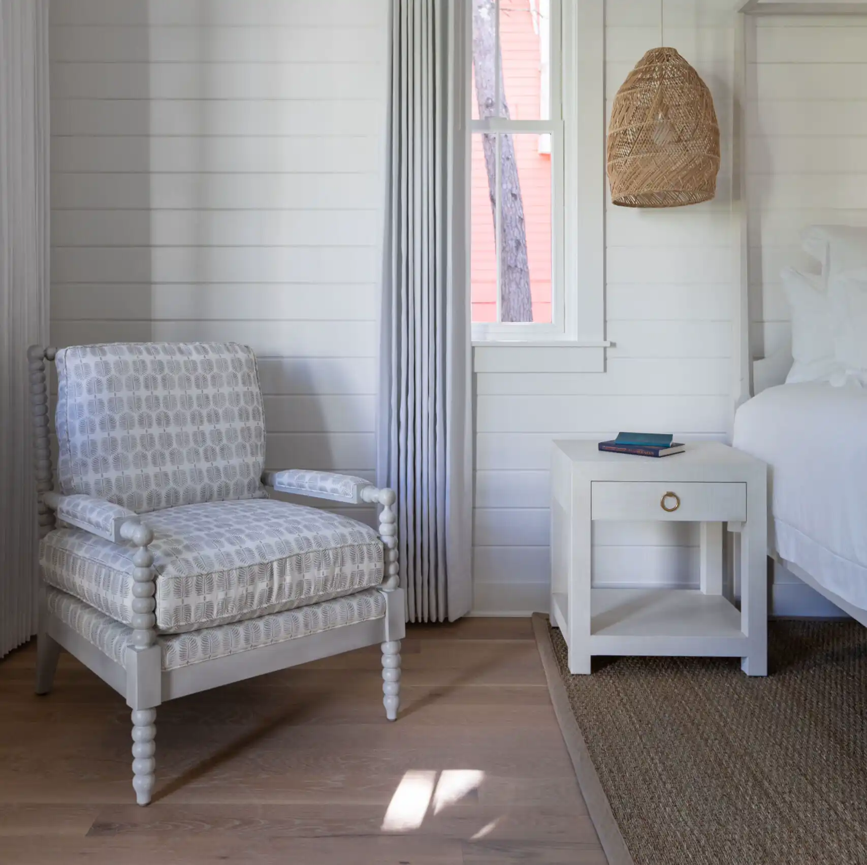Picture of the white chair in the bedroom with wooden hanging light