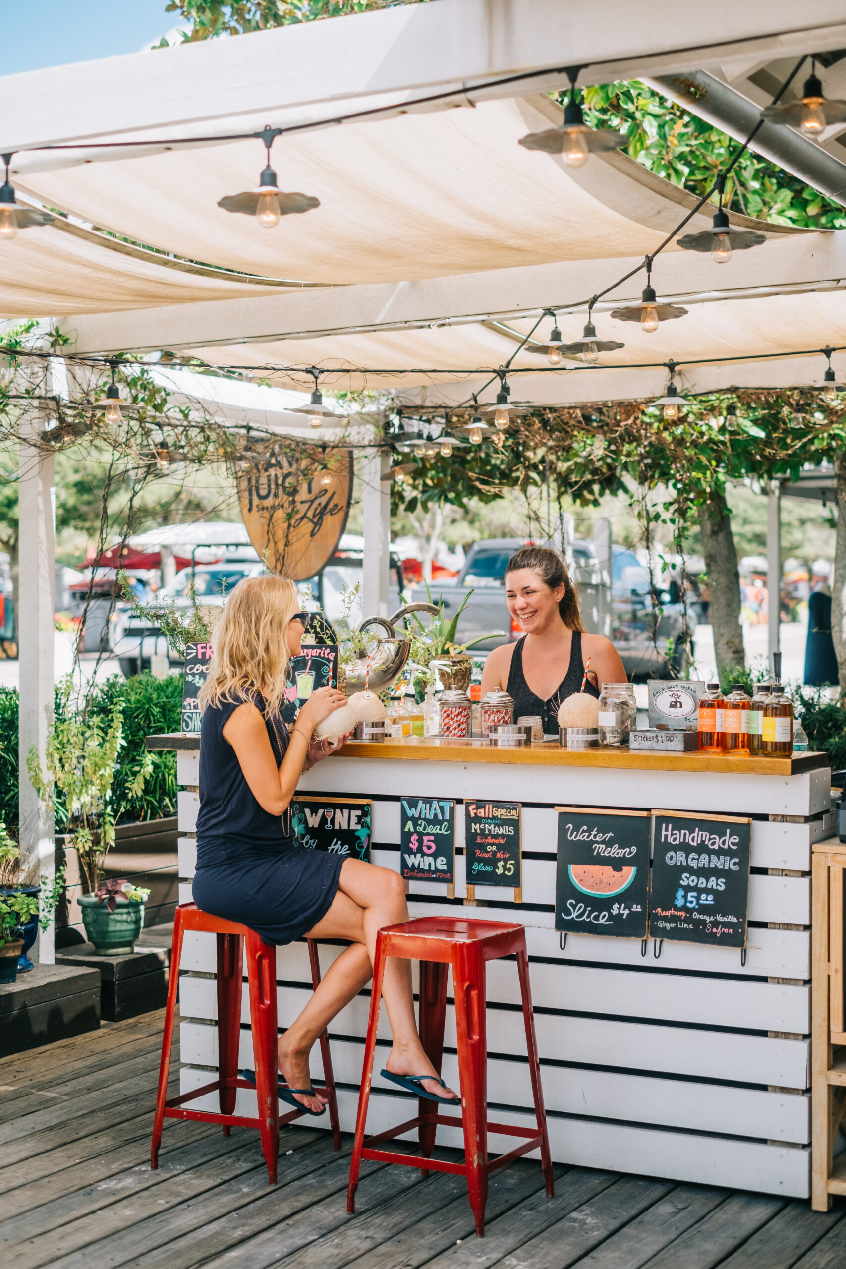 Picture of a girl sitting on the food counter and speaking with the girl